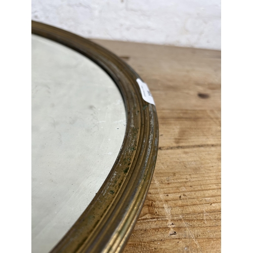 184 - A mid 20th century gilt framed oval bevelled edge wall mirror - approx. 55cm high x 80cm wide