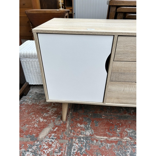 109 - An LPD Scandi oak effect sideboard with two white and grey painted cupboard doors and three central ... 