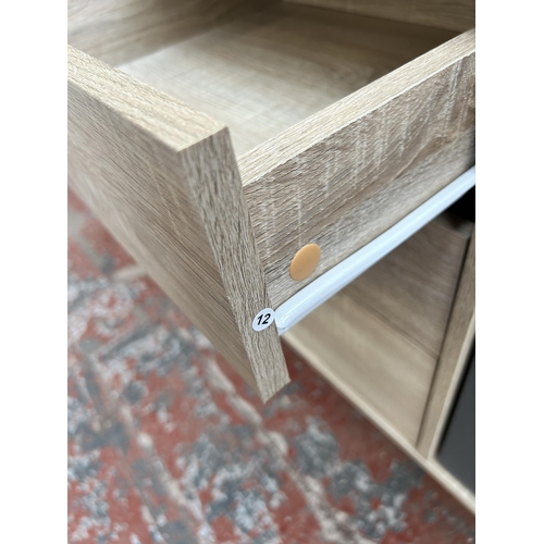 109 - An LPD Scandi oak effect sideboard with two white and grey painted cupboard doors and three central ... 