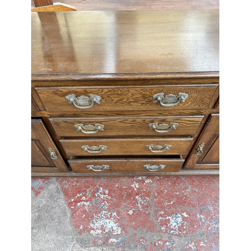 111 - A Georgian style oak sideboard with six drawers and two cupboard doors