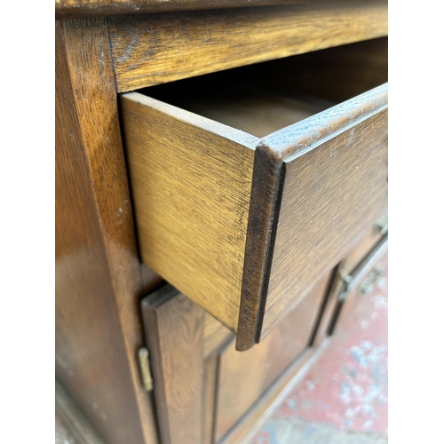 111 - A Georgian style oak sideboard with six drawers and two cupboard doors