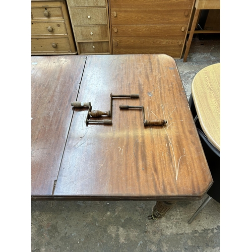 2 - A Victorian mahogany wind out dining table with reeded supports and original castors