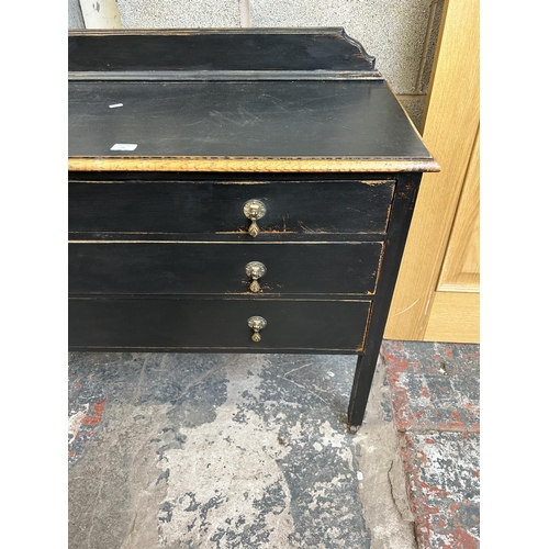 21 - An early 20th century black painted oak chest of three drawers