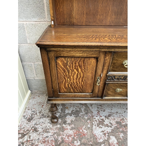 22 - An early 20th century oak dresser with upper plate rack, two drawers and two lower cupboard doors - ... 