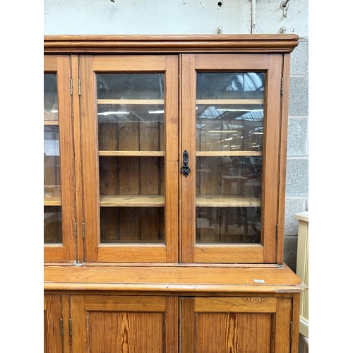 24 - A Victorian pitch pine school cupboard with four upper glazed doors and four lower cupboard doors - ... 