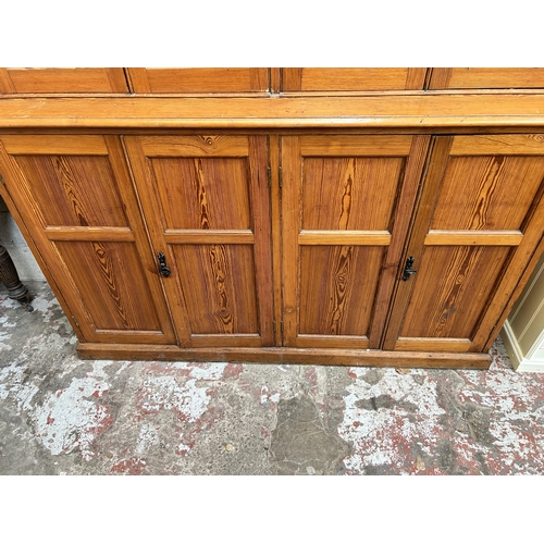 24 - A Victorian pitch pine school cupboard with four upper glazed doors and four lower cupboard doors - ... 