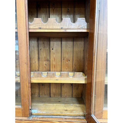 24 - A Victorian pitch pine school cupboard with four upper glazed doors and four lower cupboard doors - ... 