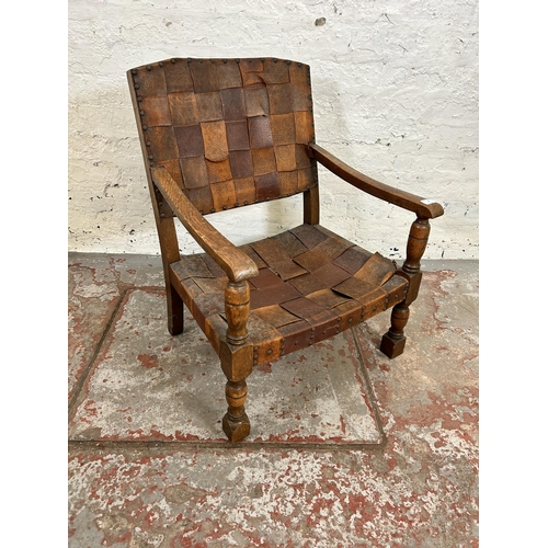 37 - A Cromwellian style leather and oak low seated armchair