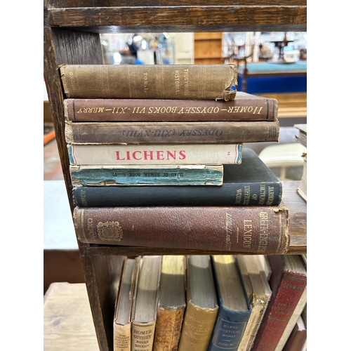 42 - An early 20th century oak three tier bookcase containing a collection of vintage books