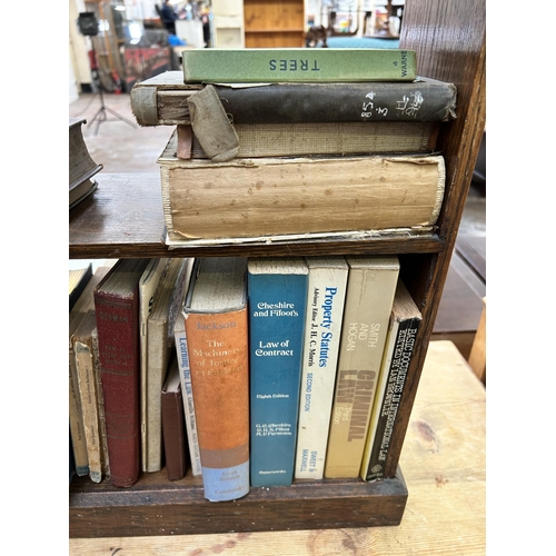 42 - An early 20th century oak three tier bookcase containing a collection of vintage books