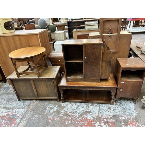 66 - Five pieces of oak furniture to include Art Deco bookcase with external newspaper rack, bedside cabi... 