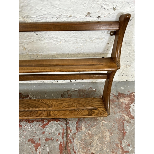 71 - An Ercol elm two tier wall hanging plate rack