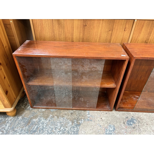 96 - Two mid 20th century stained mahogany two tier bookcases each having two glass sliding doors