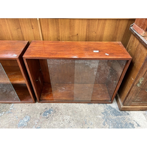 96 - Two mid 20th century stained mahogany two tier bookcases each having two glass sliding doors