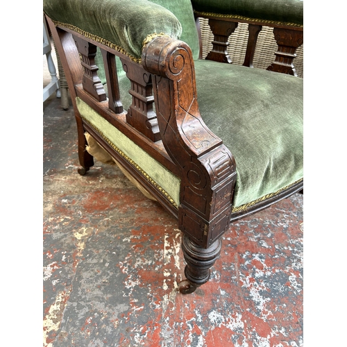 162 - A Victorian oak and green fabric upholstered armchair on castors