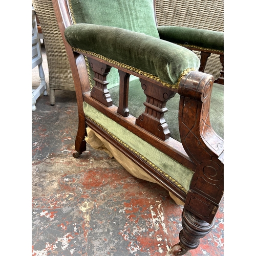 162 - A Victorian oak and green fabric upholstered armchair on castors