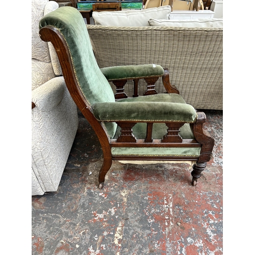 162 - A Victorian oak and green fabric upholstered armchair on castors