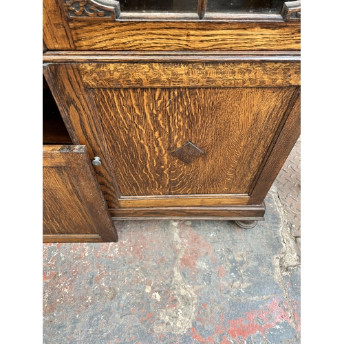 136 - An early 20th century oak bookcase with two glazed doors and two lower cupboard doors