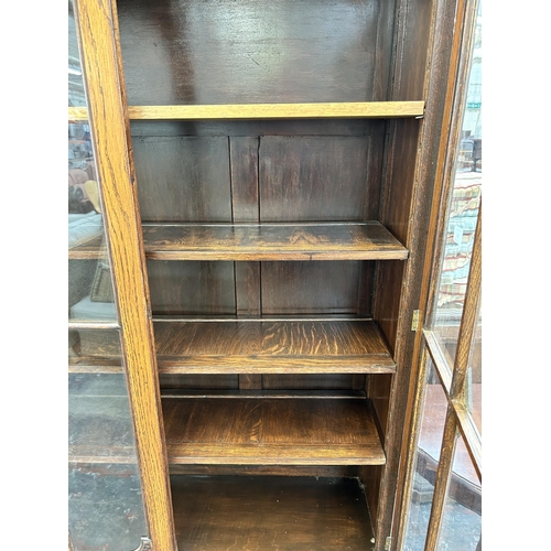 136 - An early 20th century oak bookcase with two glazed doors and two lower cupboard doors