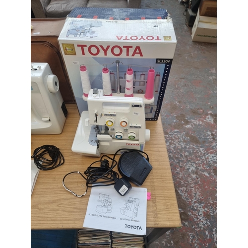 772 - A boxed Toyota SL3304 four-thread overlocking sewing machine with foot pedal and instruction manual