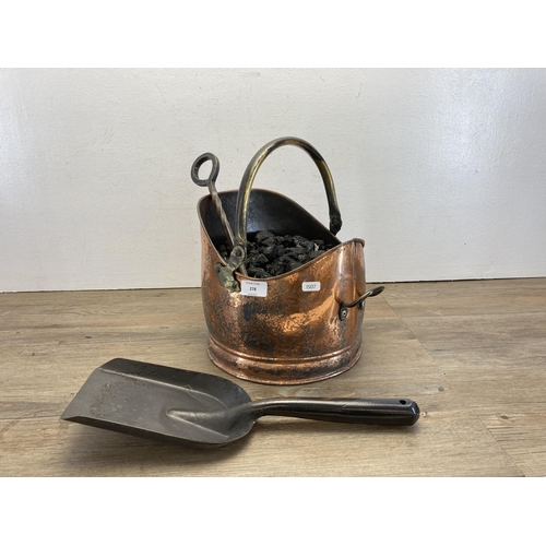 278 - A Victorian style copper helmet coal scuttle containing coal, shovel and poker