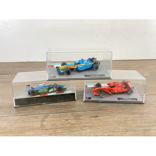 326 - A wooden display case containing twenty seven boxed Formula 1 model racing cars - display case appro... 