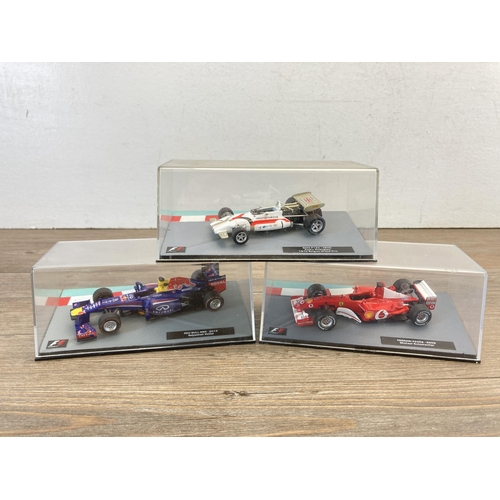 326 - A wooden display case containing twenty seven boxed Formula 1 model racing cars - display case appro... 