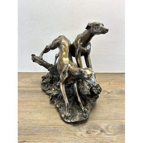 545 - A modern bronze effect figurine of two sighthounds - approx. 31cm high x 38cm long