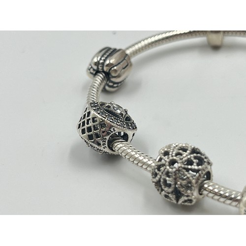 1176 - A boxed Pandora .925 silver charm bracelet with charms - approx. gross weight 34 grams