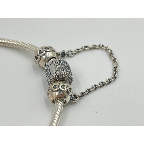 1176 - A boxed Pandora .925 silver charm bracelet with charms - approx. gross weight 34 grams