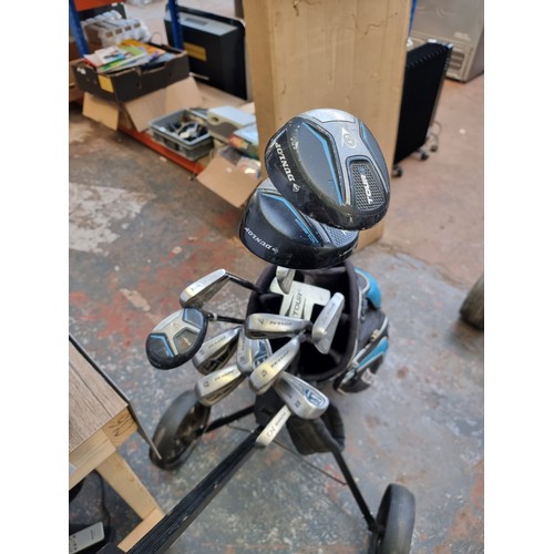 812 - A Dunlop golf bag/caddy containing fourteen Dunlop clubs to include Tour Ti titanium, Pin Seeker etc... 