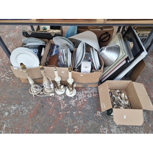 986 - Four boxes containing house clearance items to include table lamps, silver plated cutlery, ceramics,... 