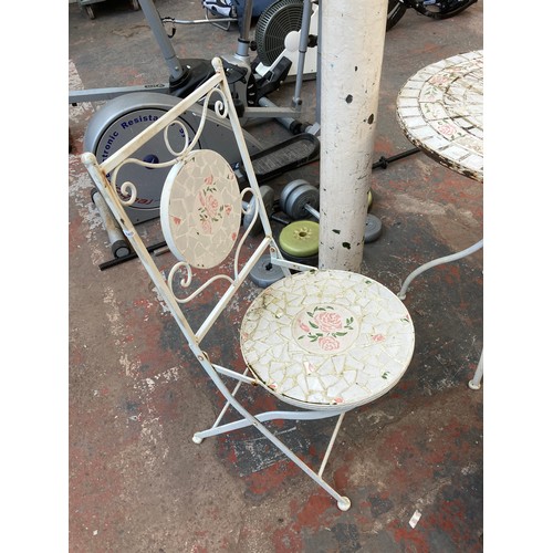 900 - A white painted metal and mosaic three piece patio set comprising circular table and two folding cha... 