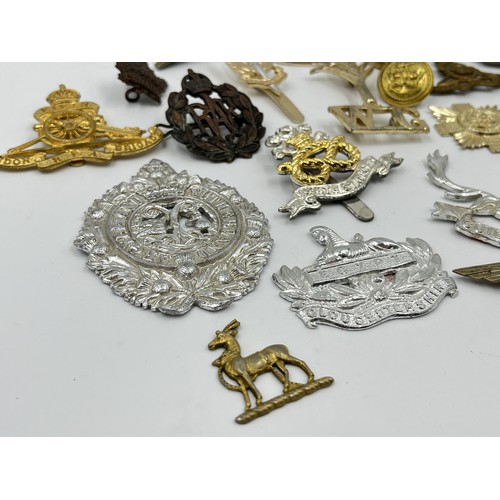 1355 - A collection of vintage military cap badges