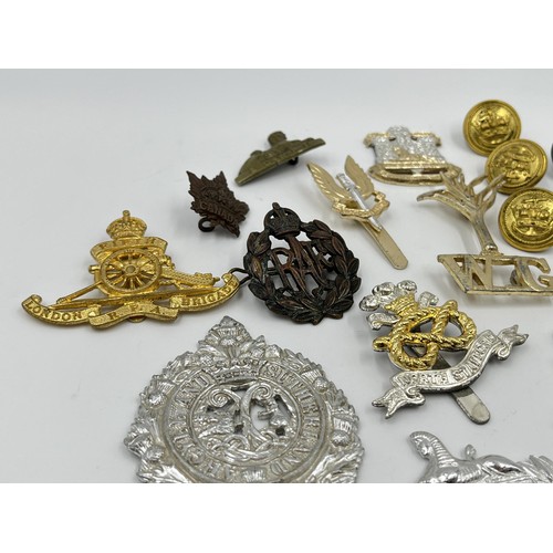 1355 - A collection of vintage military cap badges