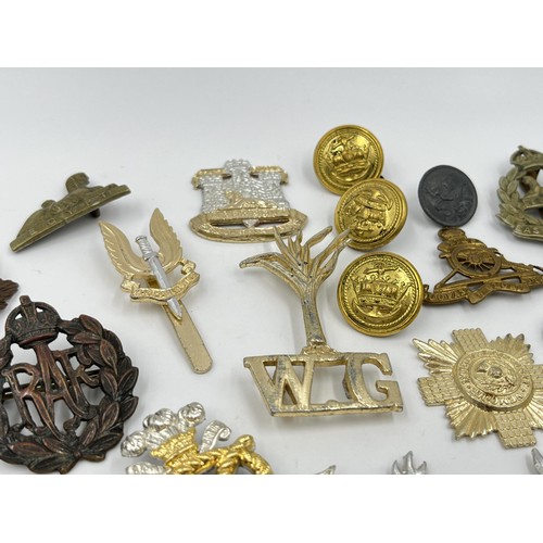 1355 - A collection of vintage military cap badges