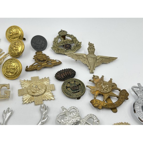 1355 - A collection of vintage military cap badges