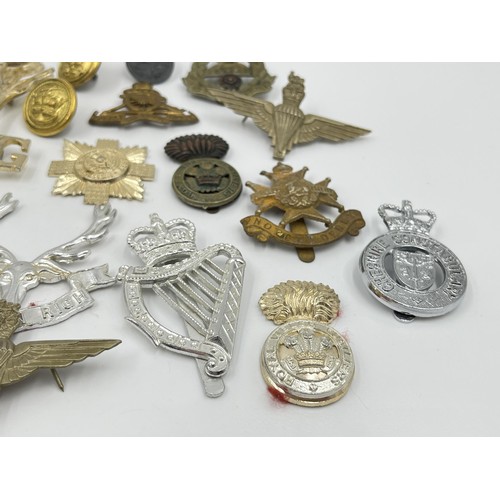 1355 - A collection of vintage military cap badges