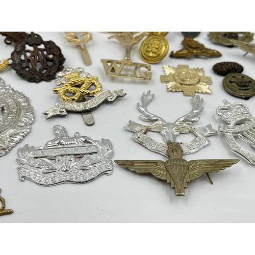 1355 - A collection of vintage military cap badges