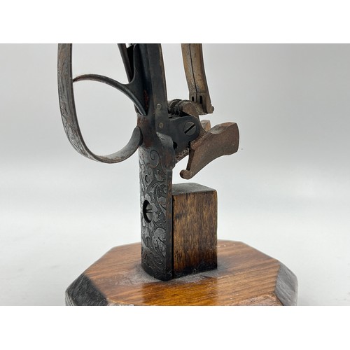 1366 - A 19th century flintlock pistol frame on wooden stand - approx. 21cm high