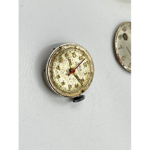 1253B - A large collection of watch parts and watchmakers accessories to include dials, movements, tools, Ro... 