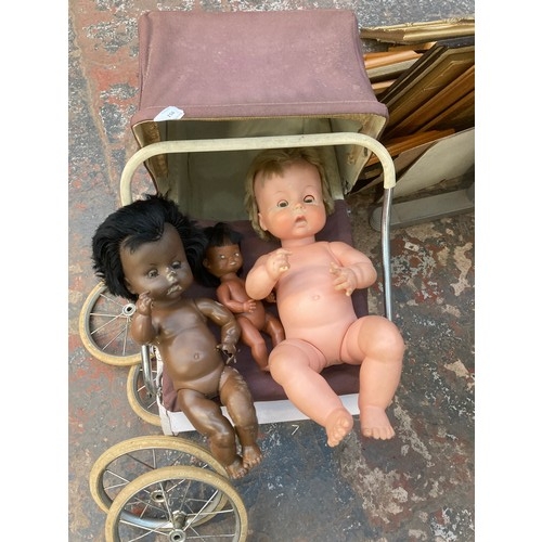 951 - A mid 20th century Tri-ang doll's pram with three dolls to include Chiltern etc.