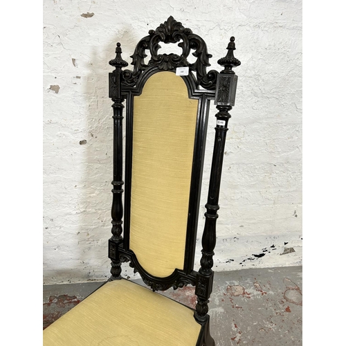 100 - A pair of Victorian ebonised low seated hall chairs