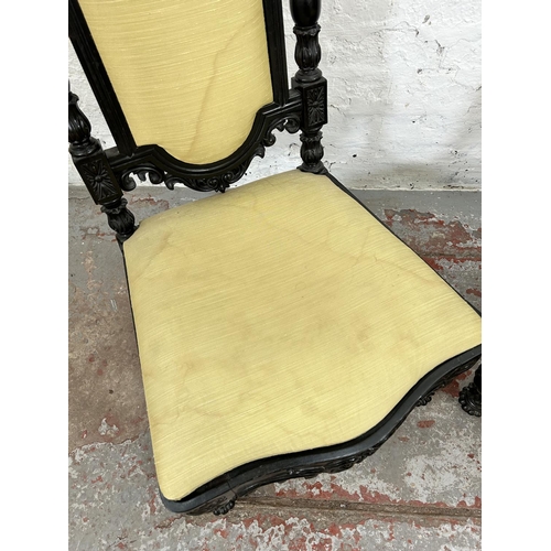 100 - A pair of Victorian ebonised low seated hall chairs