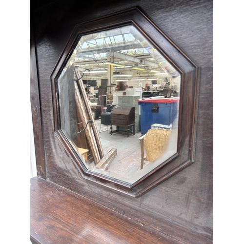 107 - An early 20th century oak hallstand with central octagonal bevelled edge mirror, two section stick s... 