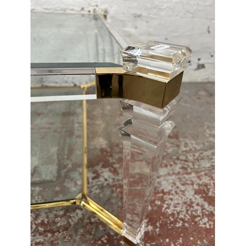 108 - A 1980s Hollywood Regency style lucite and brass effect square coffee table with two bevelled glass ... 