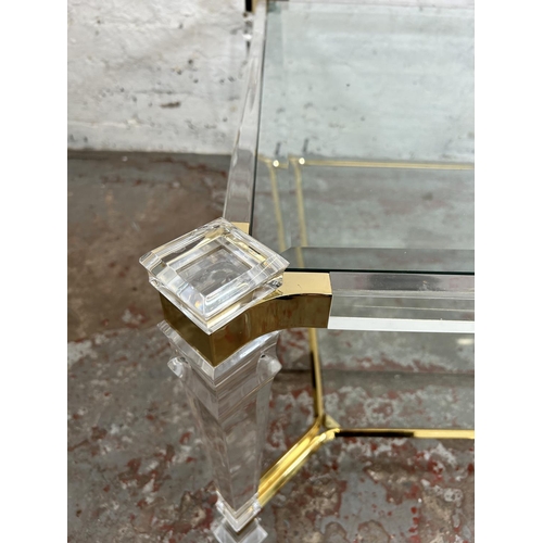 108 - A 1980s Hollywood Regency style lucite and brass effect square coffee table with two bevelled glass ... 