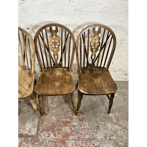 159 - A set of four beech wheelback dining chairs