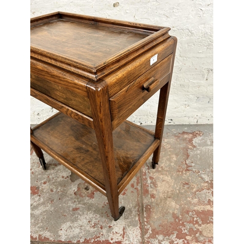 16 - A mid 20th century oak rectangular two tier serving trolley with removable tray and single drawer