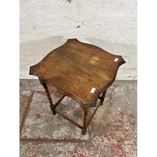 17 - An early 20th century oak serpentine side table on barley twist supports